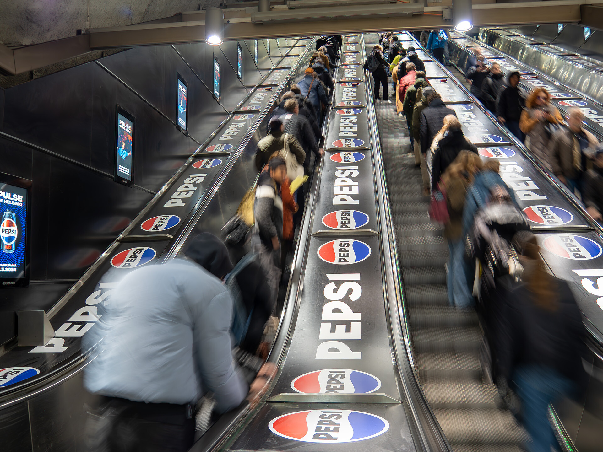 Pepsin liukuporrasteippaus Helsingin Rautatientorin metroaseman rullaportaissa.